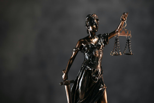 Bronze Lady Justice statue with scales and sword symbolising domestic violence laws and legal protection in Queensland.
